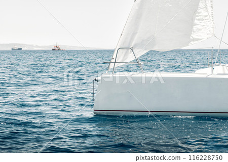 Sailboat cruising on serene sea 116228750