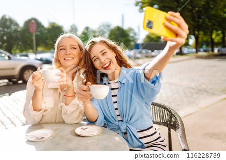 Beautiful woman friends using smartphone selfie together. Fashion, beauty, blogging, tourism. Beautiful woman friends using smartphone selfie together. Fashion, beauty, blogging, tourism. 116228789