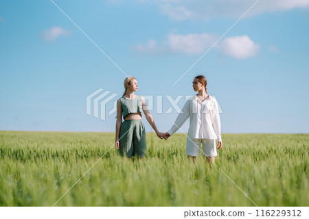 Two Beautiful woman in the green field. Nature, vacation, relax and lifestyle. Summer landscape. Two Beautiful woman in the green field. Nature, vacation, relax and lifestyle. Summer landscape. 116229312