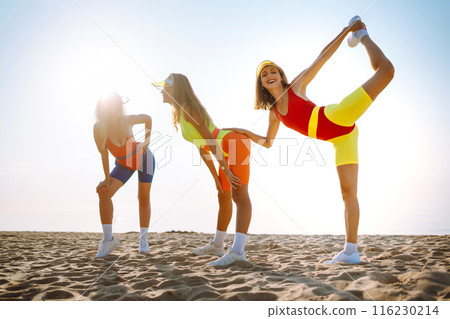 Smiling dancers in colorful swimsuits are dancing on beach ?oncept of sports, aerobics. Active sport Smiling dancers in colorful swimsuits are dancing on beach ?oncept of sports, aerobics. Active sport 116230214