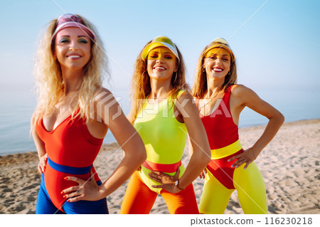 Smiling dancers in colorful swimsuits are dancing on beach ?oncept of sports, aerobics. Active sport 116230218