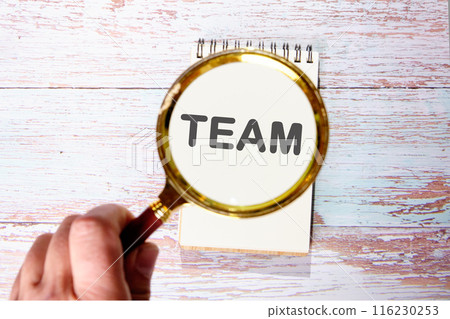 Together Everyone Achieves More. TEAM Concept. TEAM found using a magnifying glass in a notebook 116230253