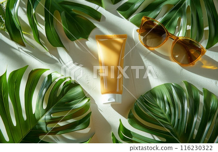 Sunscreen cream tube, sunglasses, and tropical palm leaves on a white background with shadows 116230322