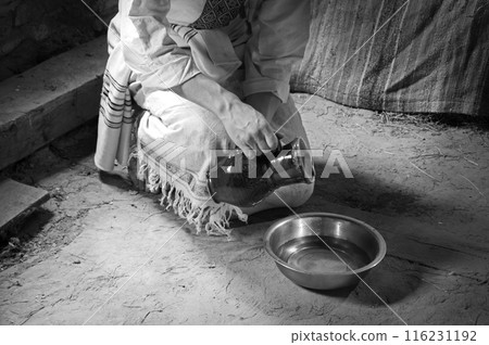 Male slave serve in the house pouring water 116231192