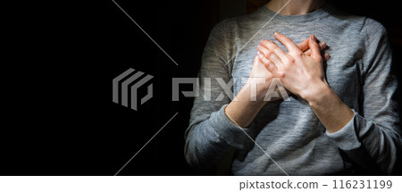 Hands folded in prayer over the heart Hands folded in prayer over the heart 116231199