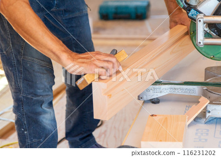 Carpenter working at a new house construction site (planing) 116231202