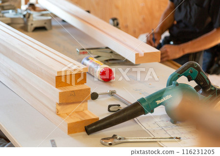Carpenter working at a construction site of a new house 116231205