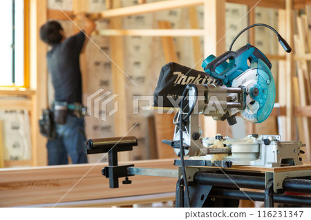 Carpenter working at a construction site of a new house 116231347