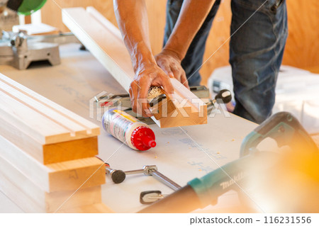 Carpenter working at a new house construction site (planing) 116231556