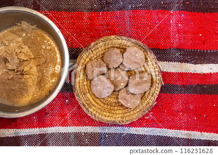 Argan oil paste and argan oil cake in metal bowl and woven basket, traditional production, Moroccan craft Argan oil paste and argan oil cake in metal bowl and woven basket, traditional production, Moroccan craft 116231628