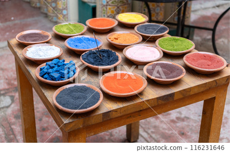 Natural color pigments powder in clay bowls on wooden table in Marrakesh, Morocco. Various vibrant colors 116231646