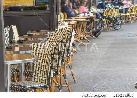 Traditional terrace in street cafe with tables and chairs in Paris, France Traditional terrace in street cafe with tables and chairs in Paris, France 116231996