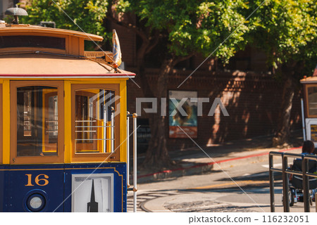 Classic San Francisco cable car, blue and yellow, number 16, headlight and gripman's platform, sunny day, historic architecture, iconic transportation. Classic San Francisco cable car, blue and yellow, number 16, headlight and gripman's platform, sunny day, historic architecture, iconic transportation. 116232051
