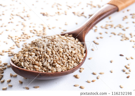 Rolled oats on wooden spoon isolated on white background, healthy breakfast cereal oat flakes  116232198