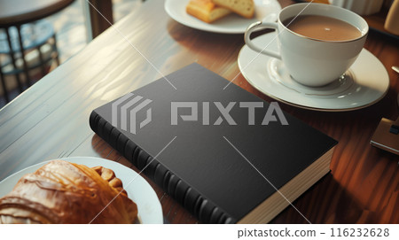 Mockup of black book with white coffee cup, cakes, and croissants on wooden table 116232628