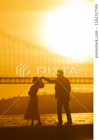 Couple Dancing at Sunset With Bridge 116232749