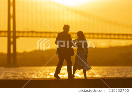 Couple Dancing at Sunset by a Bridge 116232790
