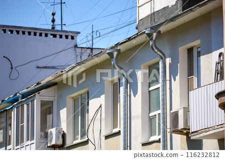 Drain pipe from the roof on the wall of the building Drain pipe from the roof on the wall of the building 116232812