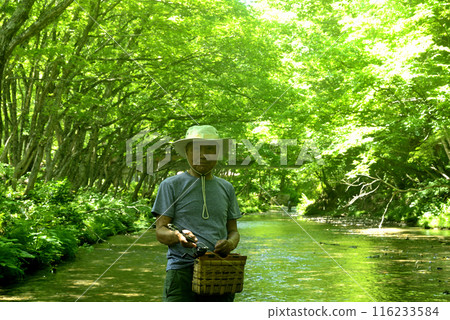 Senior man enjoying mountain stream fishing Senior man enjoying mountain stream fishing 116233584