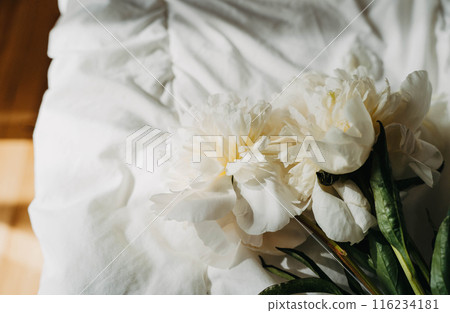 Bouquet of white peony flowers on white bad in sun light Bouquet of white peony flowers on white bad in sun light 116234181