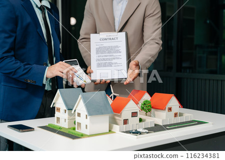 balancing the property sector The real estate agent is explaining the house style to see the house design and the purchase agreement. balancing the property sector The real estate agent is explaining the house style to see the house design and the purchase agreement. 116234381