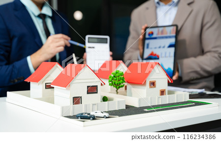 balancing the property sector The real estate agent is explaining the house style to see the house design and the purchase agreement. balancing the property sector The real estate agent is explaining the house style to see the house design and the purchase agreement. 116234386