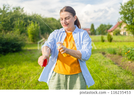 Woman applying insect repellent against mosquito, summertime health care, protection and people concept Woman applying insect repellent against mosquito, summertime health care, protection and people concept 116235453