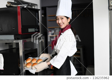 在廚房烤箱裡做麵包的年輕女人 116235962
