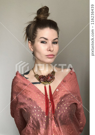 Portrait of a young woman in unusual massive necklace 116236439