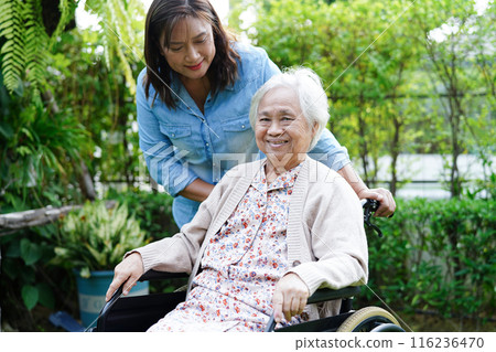 Caregiver help Asian elderly woman disability patient sitting on wheelchair in park, medical concept. 116236470