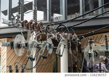 Power lines and insulators with high voltage fuses mounted on electric pole 116236557