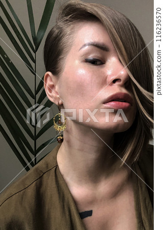 Portrait of a young woman in unusual massive jewelry Portrait of a young woman in unusual massive jewelry 116236570