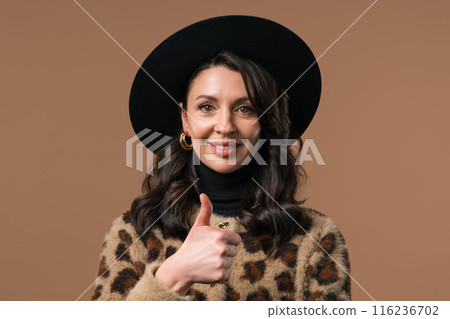 Positive woman with hand sign like, thumbs up gesture. Lady on beige background Positive woman with hand sign like, thumbs up gesture. Lady on beige background 116236702
