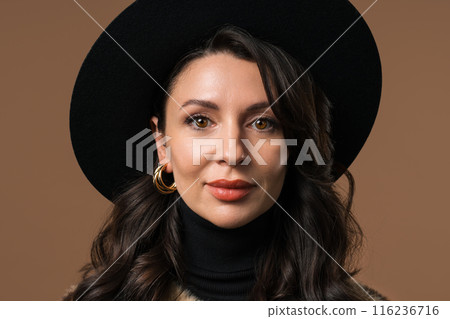 Portrait of mature woman smiling on beige background. Attractive lady in hat. 116236716