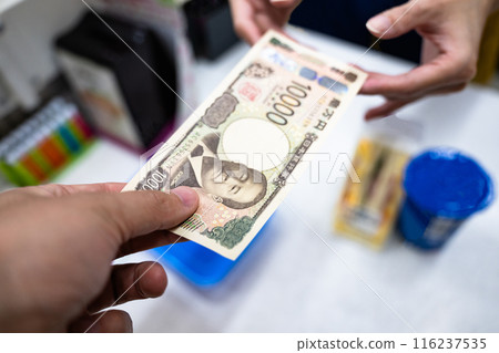 一名男子在便利商店分發 1 萬日元鈔票 116237535