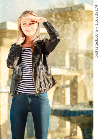 woman casual style posing against city fountain woman casual style posing against city fountain 116238174