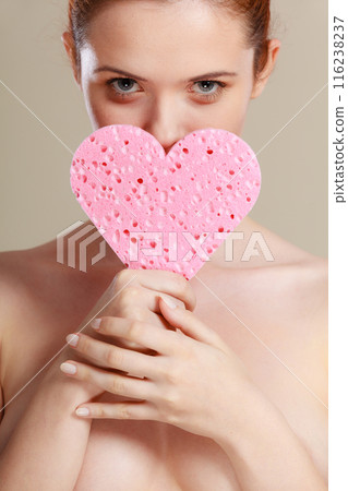 woman holding pink heart sponge in hands. 116238237