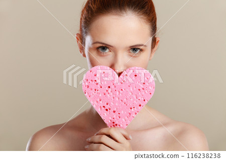 woman holding pink heart sponge in hands. woman holding pink heart sponge in hands. 116238238