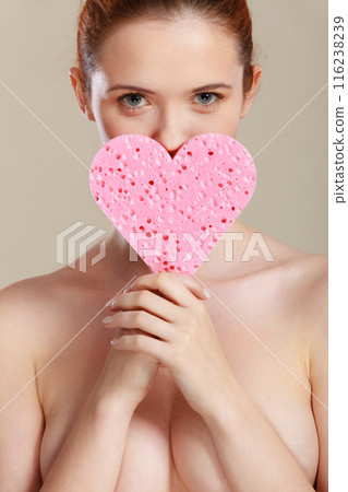 Naked woman holding pink heart sponge in hands. Naked woman holding pink heart sponge in hands. 116238239