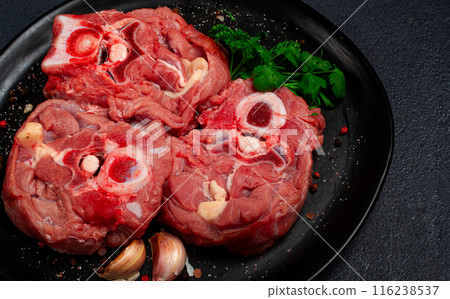 raw steak, calf's neck on the bone, fresh meat, on a black plate, top view, no people, raw steak, calf's neck on the bone, fresh meat, on a black plate, top view, no people, 116238537