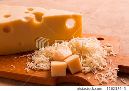 Grated cheese, Maasdam, on a cutting board, grater and cheese knife, close-up, no people, 116238643