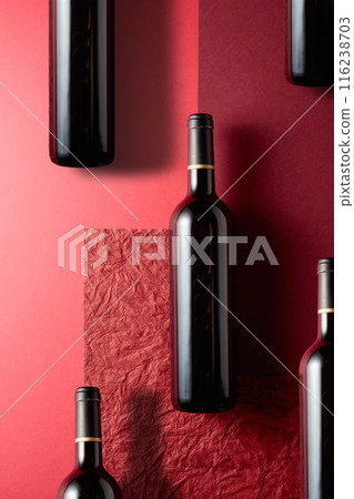 Bottles of red wine on a red background. Bottles of red wine on a red background. 116238703