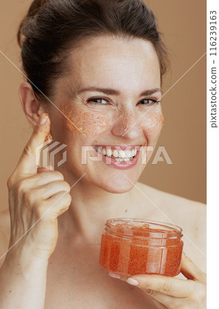 Portrait of happy modern woman with face scrub 116239163