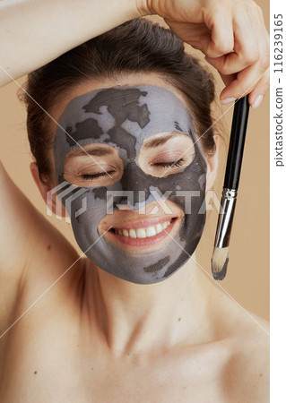 smiling modern woman with brush and facial mask 116239165