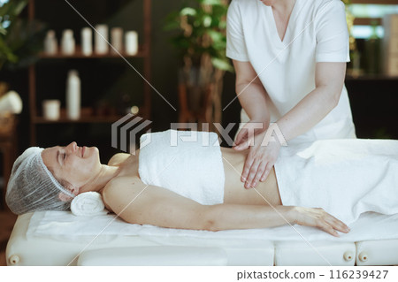 massage therapist in massage cabinet massaging clients belly massage therapist in massage cabinet massaging clients belly 116239427
