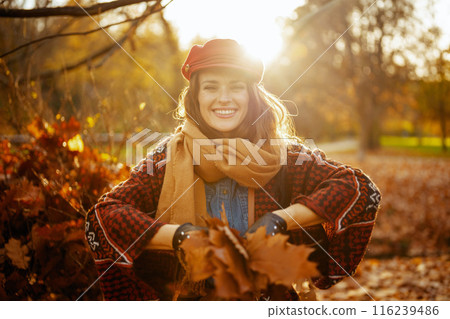 happy trendy female in red hat throwing autumn leafs happy trendy female in red hat throwing autumn leafs 116239486