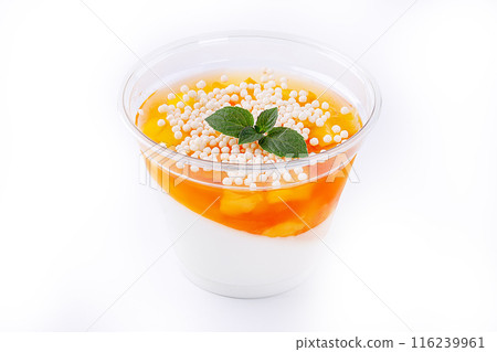 Orange panna cotta with mango slices in a glass on a white ilolate background 116239961