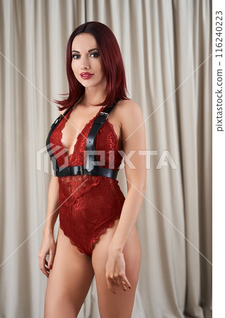 Alluring woman wearing red lingerie and harness 116240223