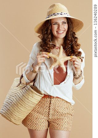 smiling elegant woman in blouse and shorts on beige smiling elegant woman in blouse and shorts on beige 116240289