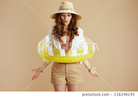 surprised housewife in blouse and shorts on beige surprised housewife in blouse and shorts on beige 116240295